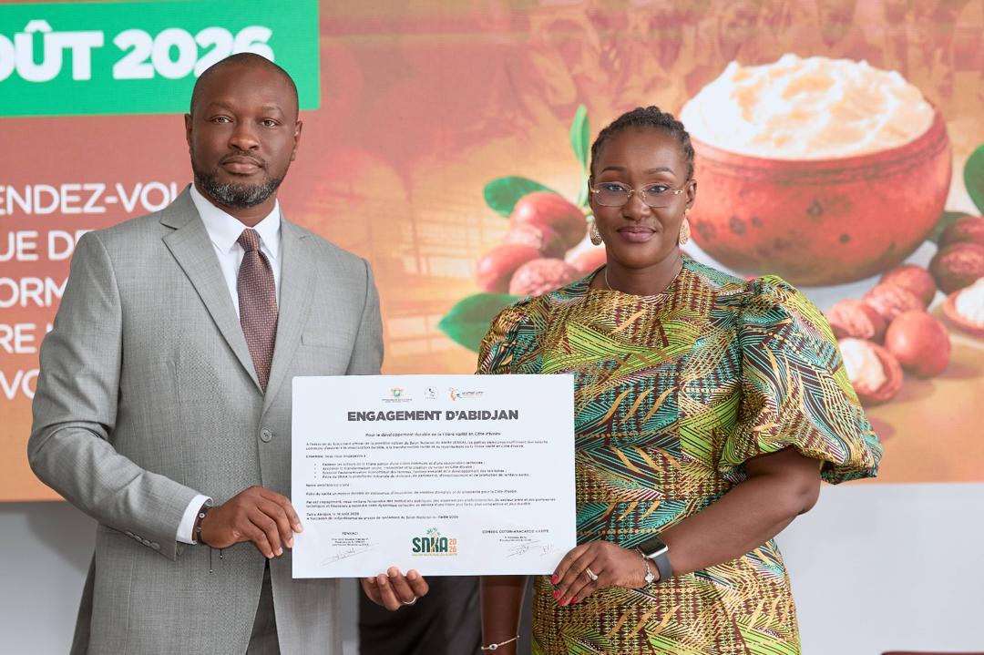 Duo souriant présentant l'Engagement d'Abidjan
